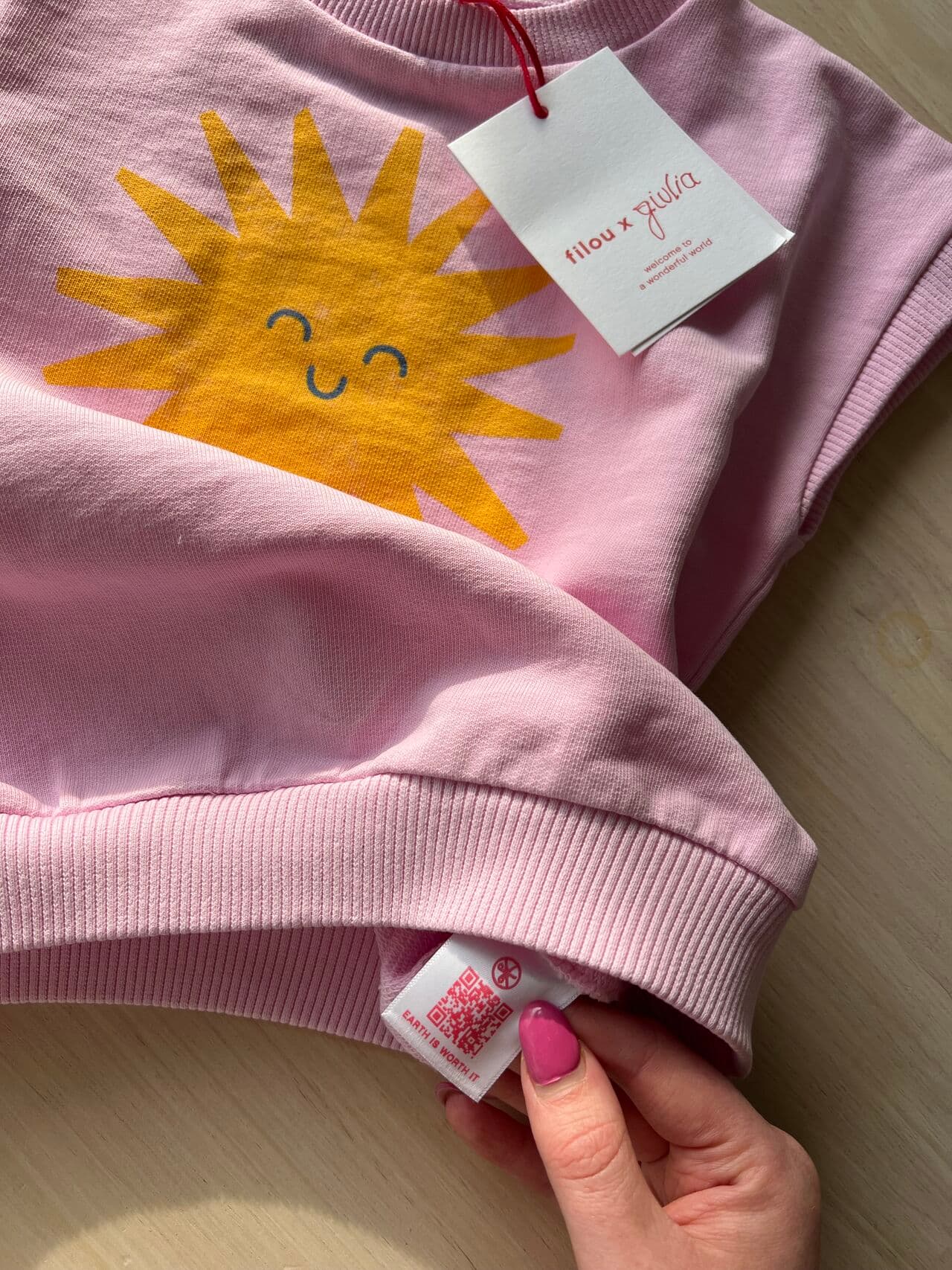 Filou x Giulia sweatshirt with the QR care label held open